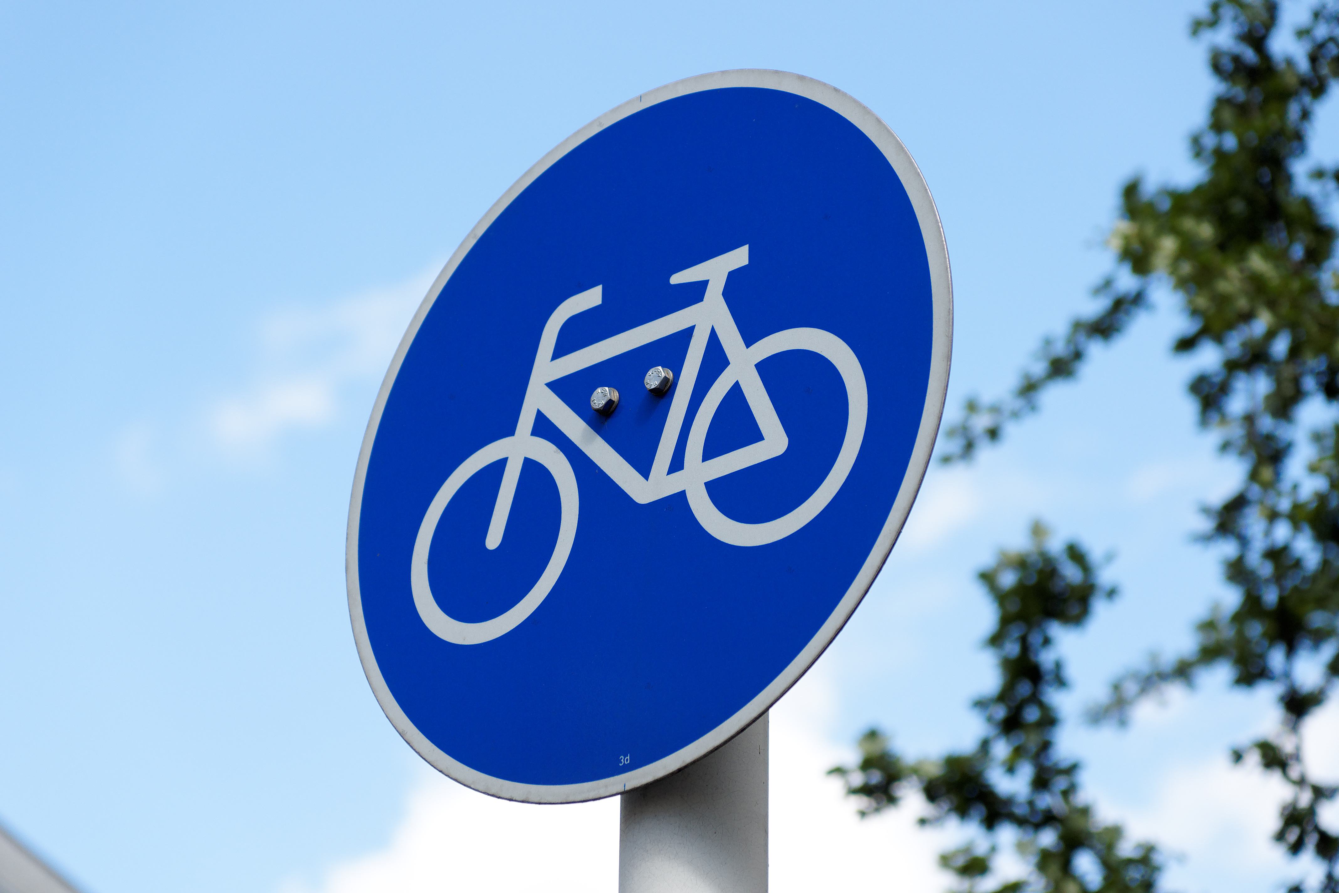 Zu sehen ist ein rundes, blaues Verkehrsschild  auf dem ein Fahrrad abgebildet ist.